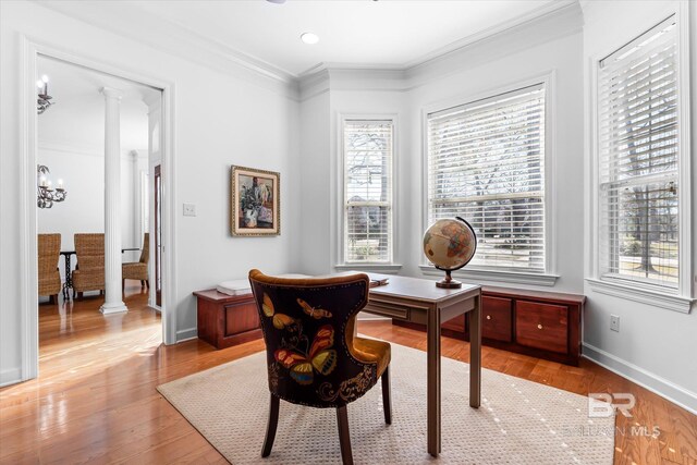 office with light wood-style floors, baseboards, crown molding, and ornate columns