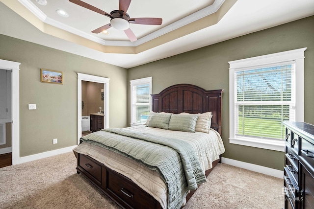 bedroom with a raised ceiling, light colored carpet, and baseboards