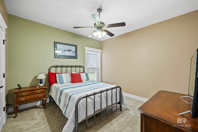 bedroom featuring light carpet, a ceiling fan, and baseboards