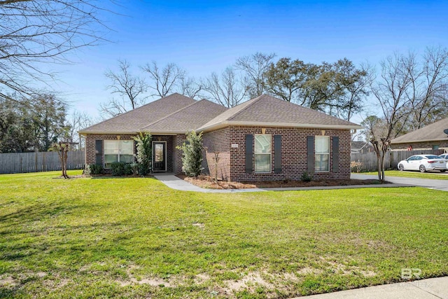 view of front of property with brick siding, roof with shingles, a front yard, and fence