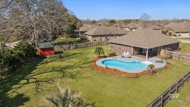 view of pool featuring a lawn, a fenced backyard, a residential view, a fenced in pool, and a patio area