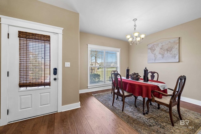 dining room with baseboards, a notable chandelier, and dark wood-style floors