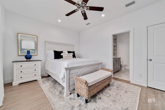 bedroom with ensuite bathroom, ceiling fan, and light wood-type flooring