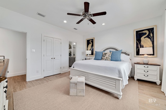 bedroom featuring connected bathroom, a closet, ceiling fan, and light hardwood / wood-style flooring