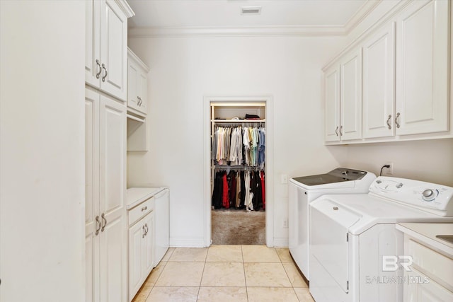 washroom with crown molding, light tile patterned floors, cabinet space, visible vents, and separate washer and dryer