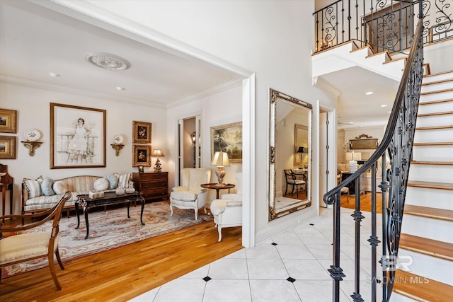 entryway featuring light tile patterned flooring, crown molding, and stairs