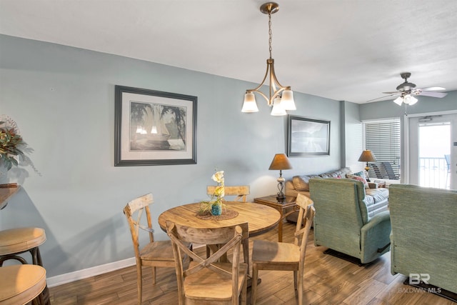 dining room with ceiling fan with notable chandelier and hardwood / wood-style floors