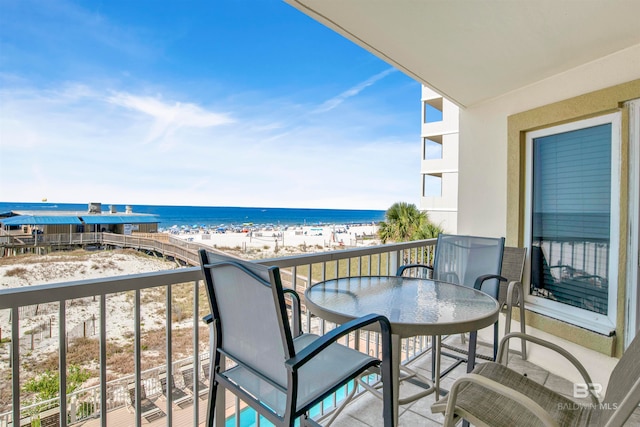 balcony featuring a water view and a beach view