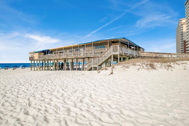 rear view of house with a water view and a beach view