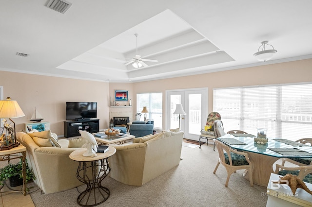 living room featuring crown molding, ceiling fan, and a raised ceiling