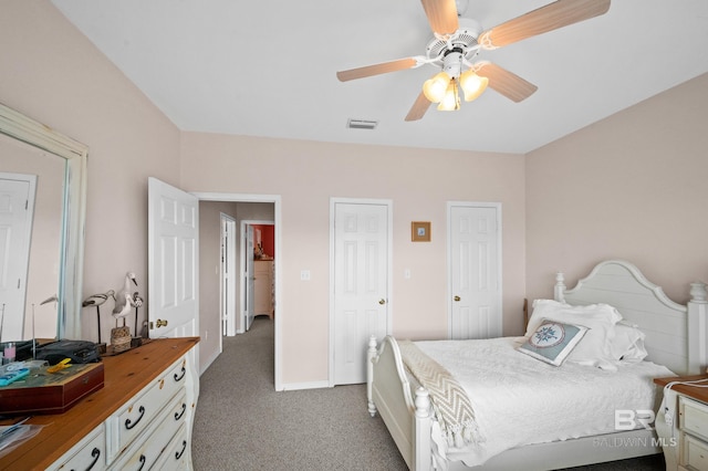 bedroom featuring carpet floors, ceiling fan, and two closets