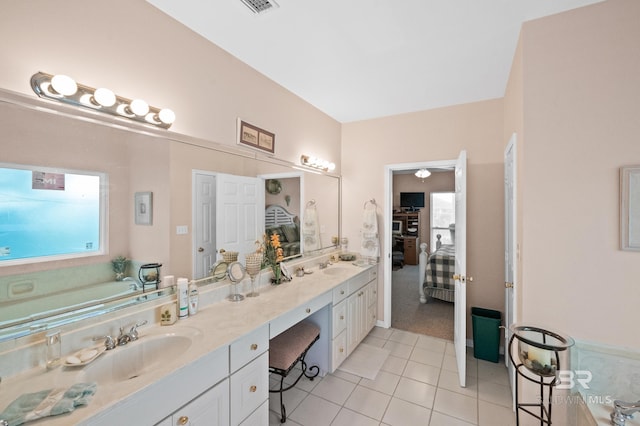 bathroom with a bathing tub, tile patterned flooring, and vanity