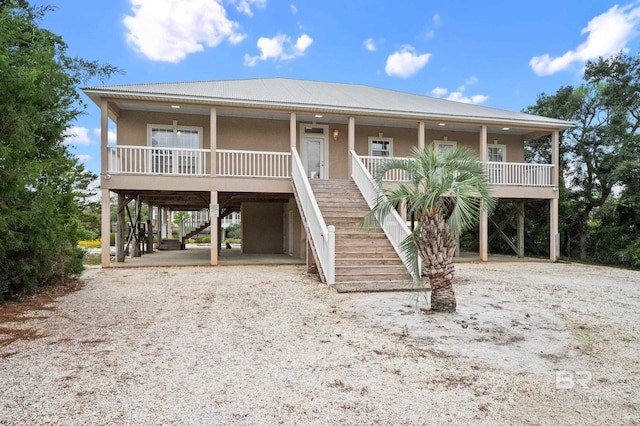 beach home featuring a porch and a carport