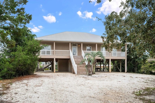 coastal inspired home featuring covered porch and a carport