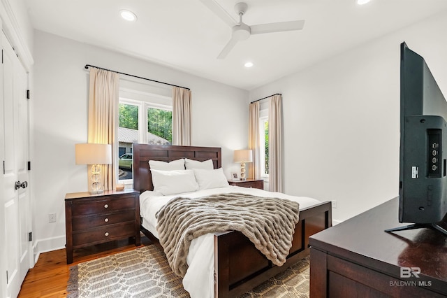 bedroom with wood finished floors, recessed lighting, a ceiling fan, and baseboards
