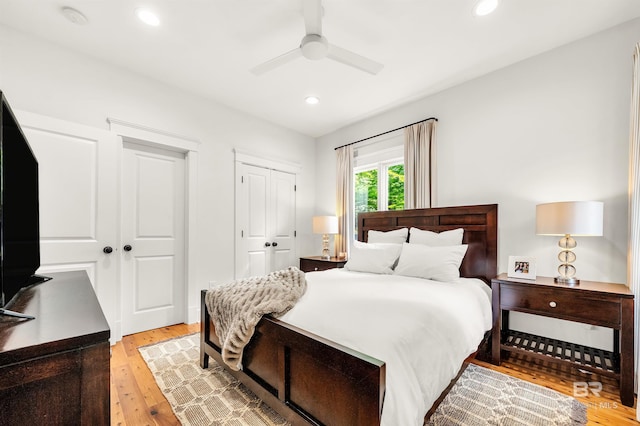 bedroom with light wood-type flooring, multiple closets, recessed lighting, and ceiling fan