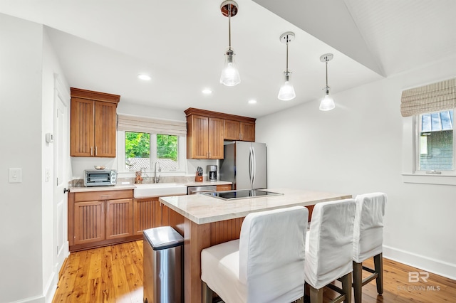 kitchen with appliances with stainless steel finishes, a sink, plenty of natural light, light countertops, and recessed lighting