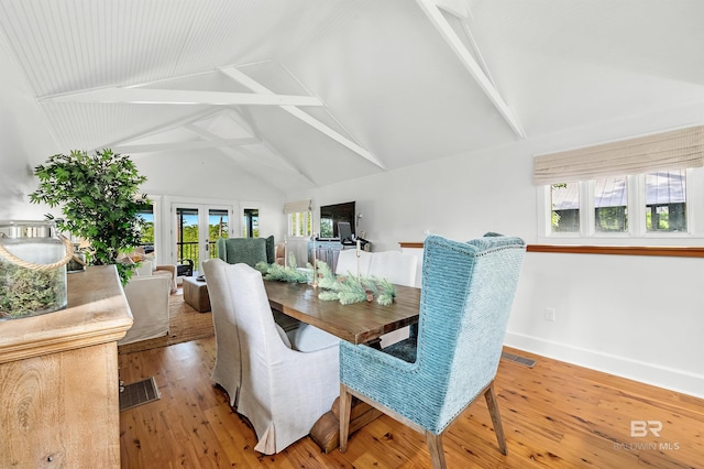 dining space featuring french doors, light wood-style floors, high vaulted ceiling, beam ceiling, and baseboards