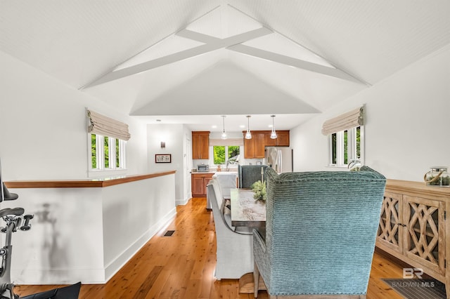 dining space featuring lofted ceiling and light wood-style flooring