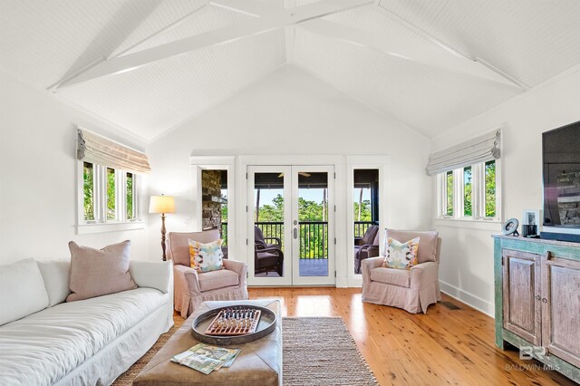 living area with french doors, light wood finished floors, vaulted ceiling, and baseboards