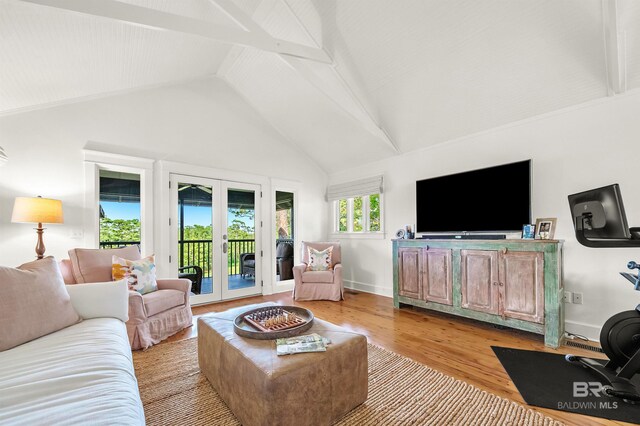 living area featuring french doors, light wood-type flooring, vaulted ceiling, and baseboards