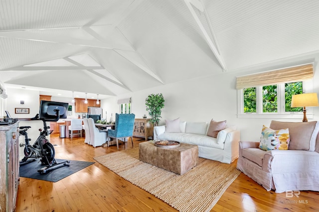 living room with light wood-type flooring, high vaulted ceiling, and beamed ceiling