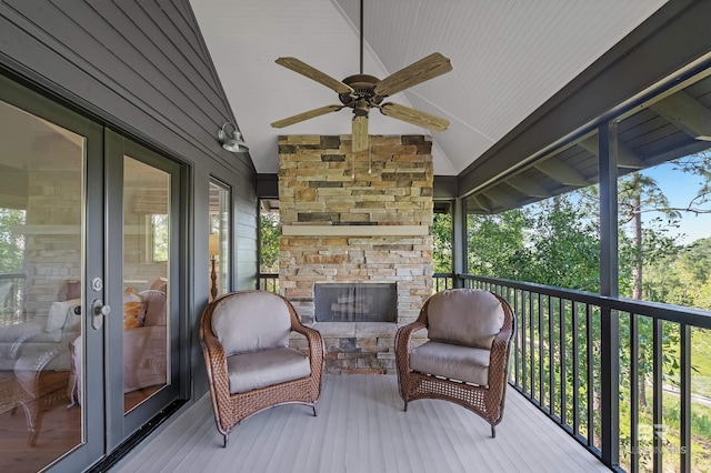 wooden deck with ceiling fan and an outdoor stone fireplace