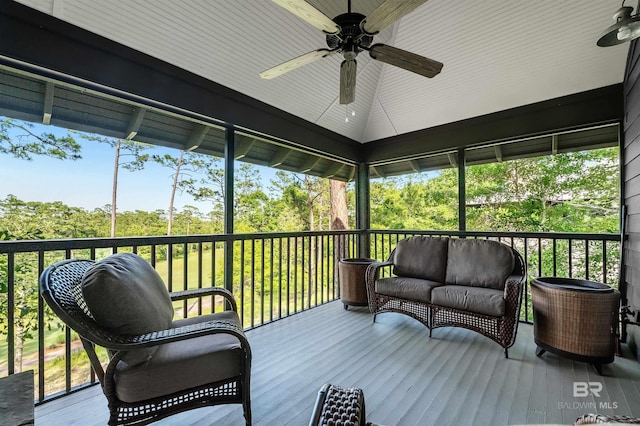 wooden deck with a ceiling fan, outdoor lounge area, and view of scattered trees
