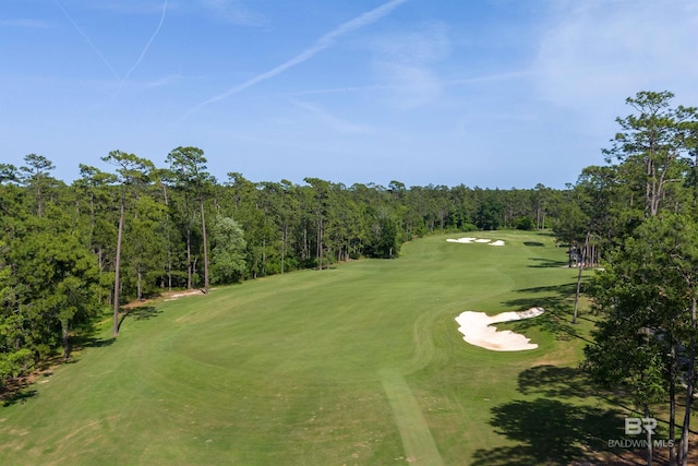 view of property's community with golf course view and a wooded view