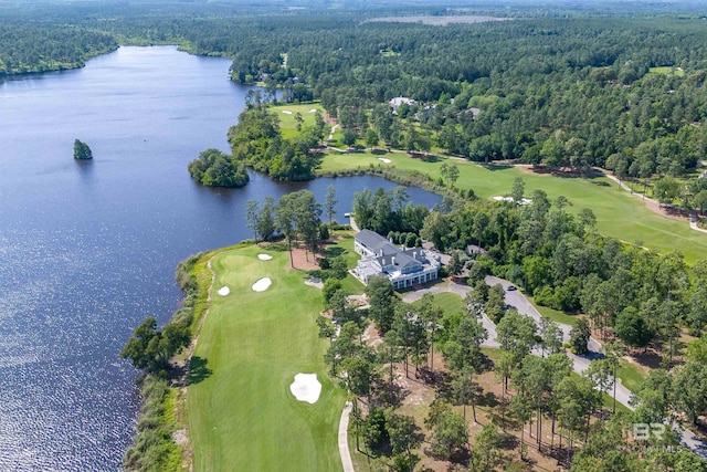 aerial view of property and surrounding area featuring a large body of water, a golf course, and a forest