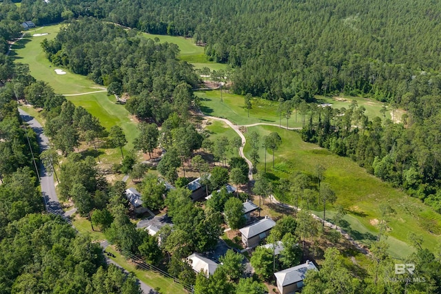 view of property location featuring a heavily wooded area and a golf course