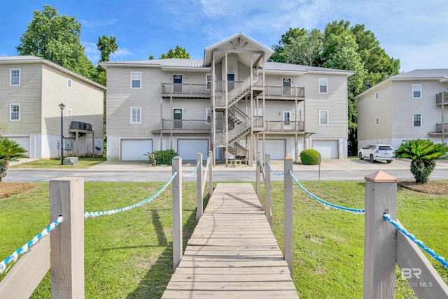 rear view of house featuring a balcony and a lawn