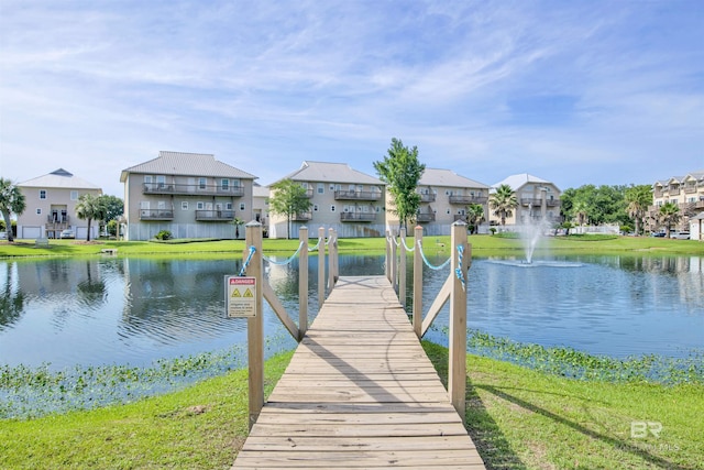 dock area with a yard and a water view