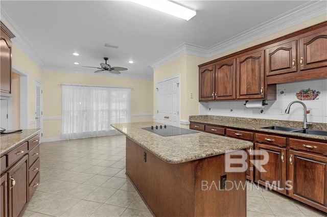 1140 E Dominion Dr, Mobile, AL 36695 - kitchen with black electric stovetop, a center island, ornamental molding, ceiling fan, and light stone countertops