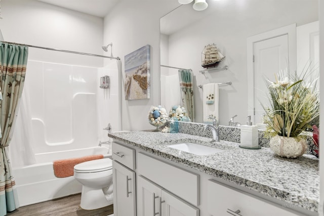 bathroom with vanity, toilet, wood finished floors, and shower / bath combo