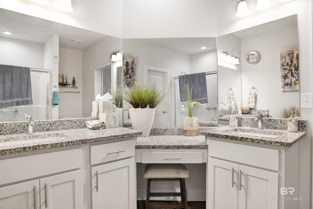 full bathroom with recessed lighting, two vanities, and a sink