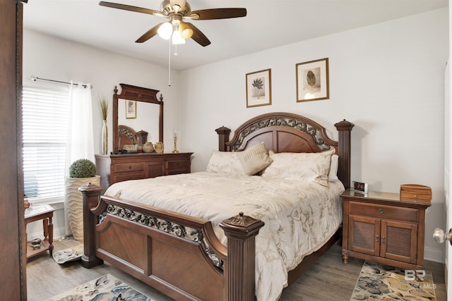 bedroom with a ceiling fan, wood finished floors, and baseboards