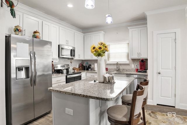 kitchen with white cabinetry, stainless steel appliances, ornamental molding, and backsplash
