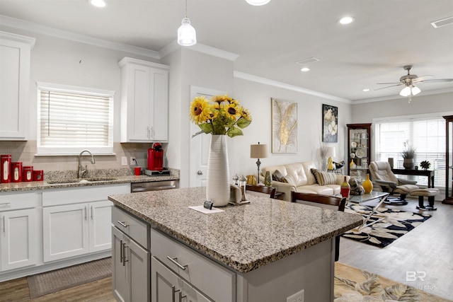 kitchen featuring a sink, recessed lighting, light wood finished floors, a ceiling fan, and a kitchen island