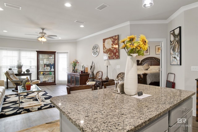 kitchen featuring ornamental molding, a ceiling fan, and visible vents