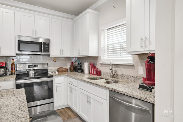 kitchen featuring white cabinetry, appliances with stainless steel finishes, tasteful backsplash, and a sink