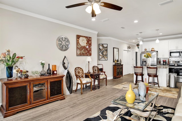 living area with crown molding, light wood-style floors, visible vents, and recessed lighting