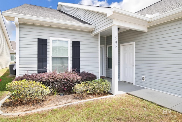 entrance to property featuring roof with shingles