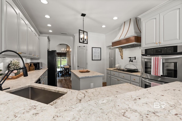14281 Timber Ridge Dr, Loxley, AL 36551 - kitchen with premium range hood, a chandelier, black appliances, ornamental molding, and light stone counters