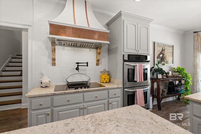 14281 Timber Ridge Dr, Loxley, AL 36551 - kitchen featuring double oven, custom range hood, black electric cooktop, dark wood-style floors, and ornamental molding