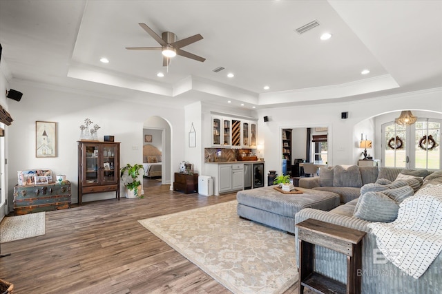 14281 Timber Ridge Dr, Loxley, AL 36551 - living room with arched walkways, a raised ceiling, wine cooler, a bar, and crown molding