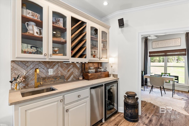 14281 Timber Ridge Dr, Loxley, AL 36551 - indoor wet bar featuring refrigerator, beverage cooler, crown molding, decorative backsplash, and light wood-style flooring
