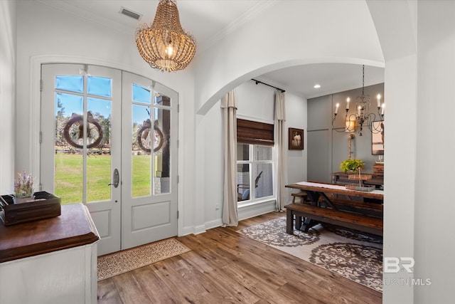 14281 Timber Ridge Dr, Loxley, AL 36551 - entrance foyer with a chandelier, arched walkways, ornamental molding, wood finished floors, and french doors