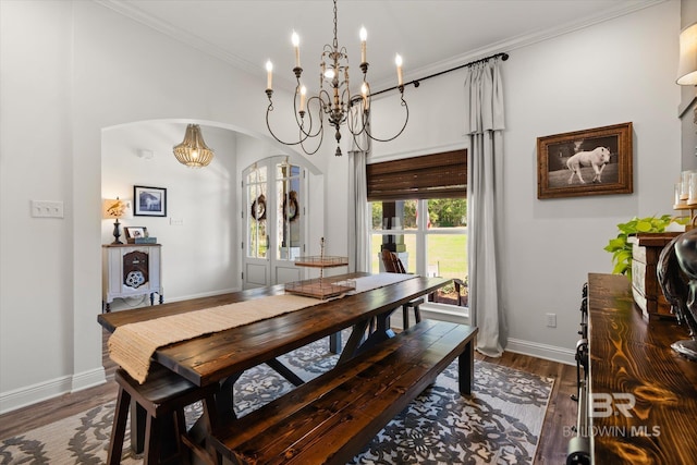 14281 Timber Ridge Dr, Loxley, AL 36551 - dining space with a chandelier, arched walkways, wood finished floors, ornamental molding, and a high ceiling
