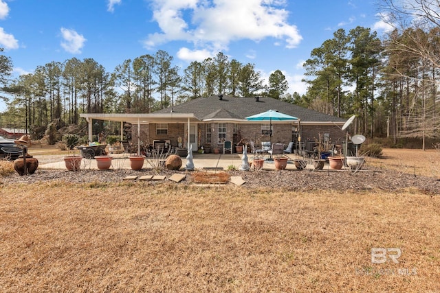 rear view of property featuring a lawn and a patio